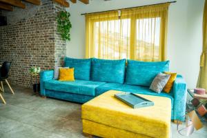 Un sofá azul en una sala de estar con una mesa. en Studio54, en Veliko Tŭrnovo
