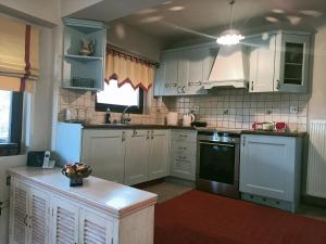 a kitchen with white cabinets and a stove top oven at Amadrias Villa Florina in Florina