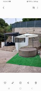 a picnic table with an umbrella and green grass at Casa Azul Mountain Retreat in Vega de San Mateo