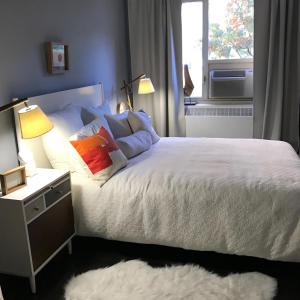 a bedroom with a white bed with pillows and a window at THE CENTRAL PARK EAST by THE MUSEUM MILE in New York