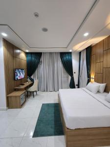 a bedroom with a bed and a desk and a television at Samuel Court in Abuja