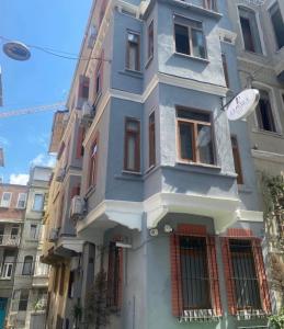 een blauw gebouw met ramen aan een stadsstraat bij La pella suit in Istanbul