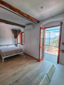 コルニリアにあるBelvedere Affittacamereのベッドルーム1室(ベッド1台付)、大きなスライド式ガラスドアが備わります。