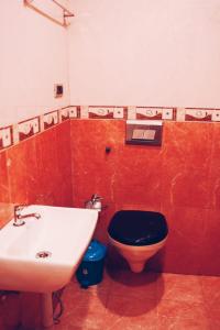 a bathroom with a black toilet and a sink at Silver Homes Homestay in Alwaye