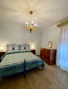 a bedroom with a blue bed and a chandelier at Casa Vacanze Il Borgo in Gubbio
