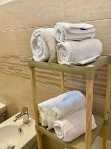 un mucchio di asciugamani su una mensola in bagno di Casa Vacanze Il Borgo a Gubbio
