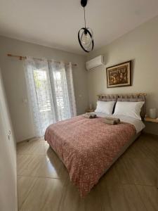 a bedroom with a large bed with a red blanket at Olea Luxury Apartment in Pythagoreio