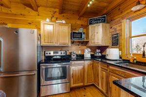 a kitchen with wooden cabinets and a stainless steel refrigerator at Lost Indian Hideaway in Whittier