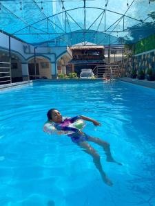 un joven nadando en una piscina en villa paguio hot spring resort, en Calambá