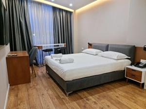 1 dormitorio con cama, escritorio y mesa en Star Hotel Astir en Tirana