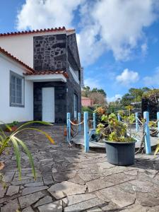 una casa con una recinzione di fronte di Alojamentos A Buraca a São Roque do Pico
