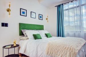una camera bianca con un grande letto con accenti verdi di Casa Palma 2 a La Paz