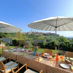 a table with plates of food and an umbrella at B&B Il Fienile San Gimignano in San Gimignano