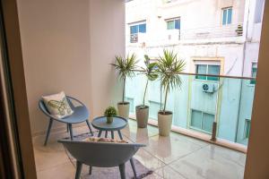 a balcony with two chairs and a table and potted plants at Anfa Flores in Casablanca