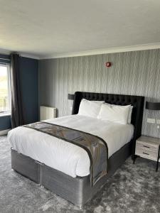 a bedroom with a large bed and a table at Dolphin Hotel Cambridge in St. Ives