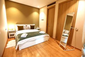 a bedroom with a large bed and a mirror at Anfa Flores in Casablanca