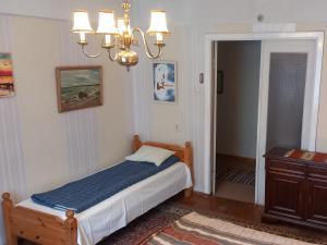 a bedroom with a bed and a chandelier at Majakovski Guesthouse in Sillamäe