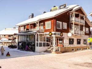 a large wooden building with snow on top of it at Party condo in the center of Levi in Levi