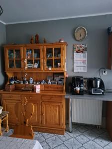 a kitchen with a wooden cabinet and a counter at Dom Wakacyjny U BARBASI - 7 DNI W DOBREJ CENIE ! in Chmielno