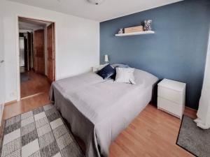 a bedroom with a large bed with a blue wall at Party condo in the center of Levi in Levi