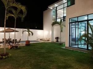 a house with a patio with palm trees in the yard at Bella Casa Blanca in El Castillo