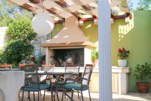 a patio with a table and chairs and a fireplace at Olive Hill in Žrnovo