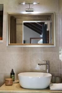 La salle de bains est pourvue d'un lavabo blanc et d'un miroir. dans l'établissement Olive Hill, à Žrnovo