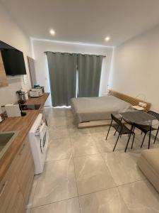 ein Wohnzimmer mit einem Bett und einem Tisch sowie eine Küche in der Unterkunft ARF Apartments in Emba