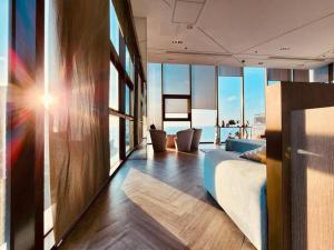 a room with a bed and a living room with windows at Best Pool with 360 View of Pattaya & Best Location in Pattaya Central +52 photos