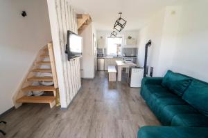 a living room with a green couch and a kitchen at Sunsar in Sarbinowo