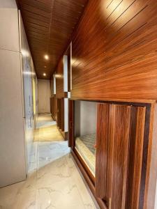 Habitación con paredes revestidas de madera y habitación con cama. en Yoi Pod Hostel en Dubái