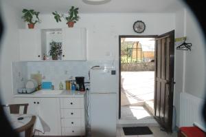 uma cozinha com um frigorífico e uma porta para um quintal em Mare - Mare B em Patra