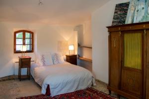 a bedroom with a bed and a dresser and a window at Spacious stylish Provencal house with terrace in Saignon
