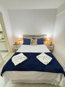 a bedroom with a large bed with blue sheets and pillows at Apartamento JTR Cond Beira Mar - Castelo B Temporada in Maceió
