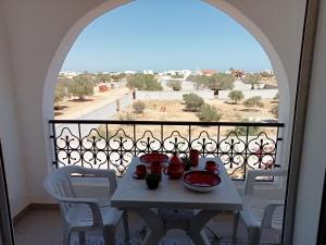 una mesa con tazones de comida en el balcón en Villa Arkou Midoun, en Midoun