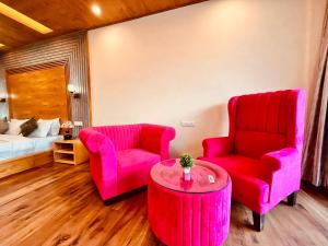 sala de estar con 2 sillas y mesa en Rockland Cottage, Manali - Centrally Heated & Air Cooled Premium Rooms en Manāli