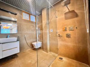 a bathroom with a shower and a toilet and a sink at Rockland Cottage, Manali - Centrally Heated & Air Cooled Premium Rooms in Manāli