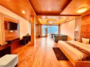 Habitación de hotel con cama y sofá en Rockland Cottage, Manali - Centrally Heated & Air Cooled Premium Rooms en Manāli