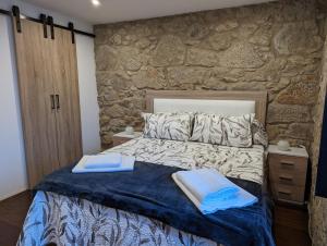 a bedroom with a bed with two towels on it at Casa Madrelejo in Outes