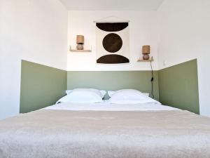 ein Schlafzimmer mit einem weißen Bett mit zwei Kissen in der Unterkunft Haut Foirail, Balcon Centre-Ville in Espalion