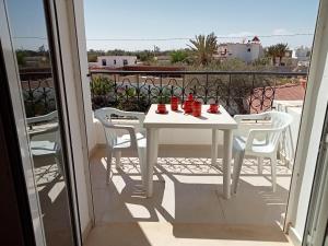 - Balcón con mesa blanca y sillas en Villa Arkou Midoun en Midoun