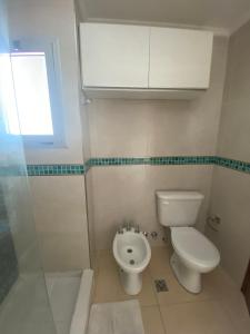 a bathroom with a toilet and a sink at Moderno departamento en el centro in Concordia