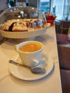 une tasse de café sur une assiette avec une cuillère dans l'établissement Hotel Acropolis, à Varna