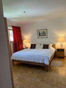 a bedroom with a bed and two lamps and a window at Jagdhäusl in Ramsau