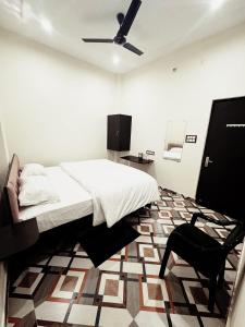 - une chambre avec un lit et une chaise noire dans l'établissement Vrinda Garden, à Varanasi