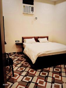 a bedroom with a bed with a tiled floor at Vrinda Garden in Varanasi