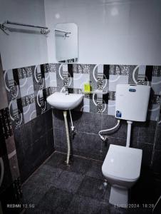 ein Badezimmer mit einem weißen WC und einem Waschbecken in der Unterkunft Vrinda Garden in Varanasi