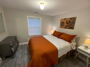 a bedroom with a bed with an orange blanket at Hilltop Haven w/Creek&Waterfall Dntwn McCaysville in McCaysville