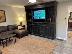 a living room with a couch and a flat screen tv at Hilltop Haven w/Creek&Waterfall Dntwn McCaysville in McCaysville