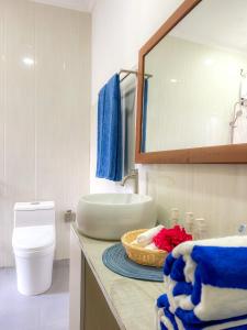 ein Bad mit einem Waschbecken und einem Korb mit Handtüchern in der Unterkunft Hide Inn Blue in Nilandhoo